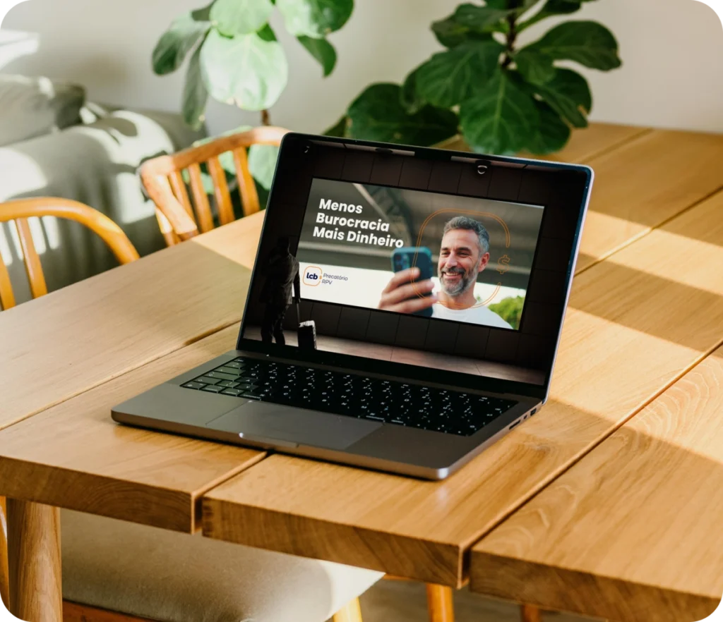 Laptop na mesa exibindo vídeo sobre menos burocracia e mais dinheiro