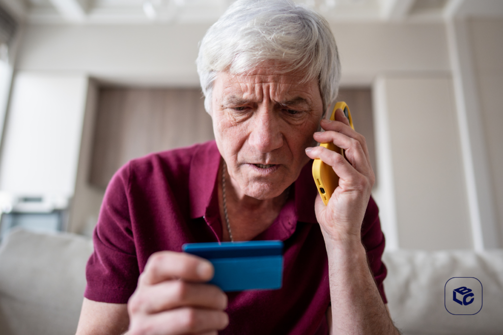 Homem idoso preocupado ao telefone com cartão de crédito azul, possível golpe de RPV